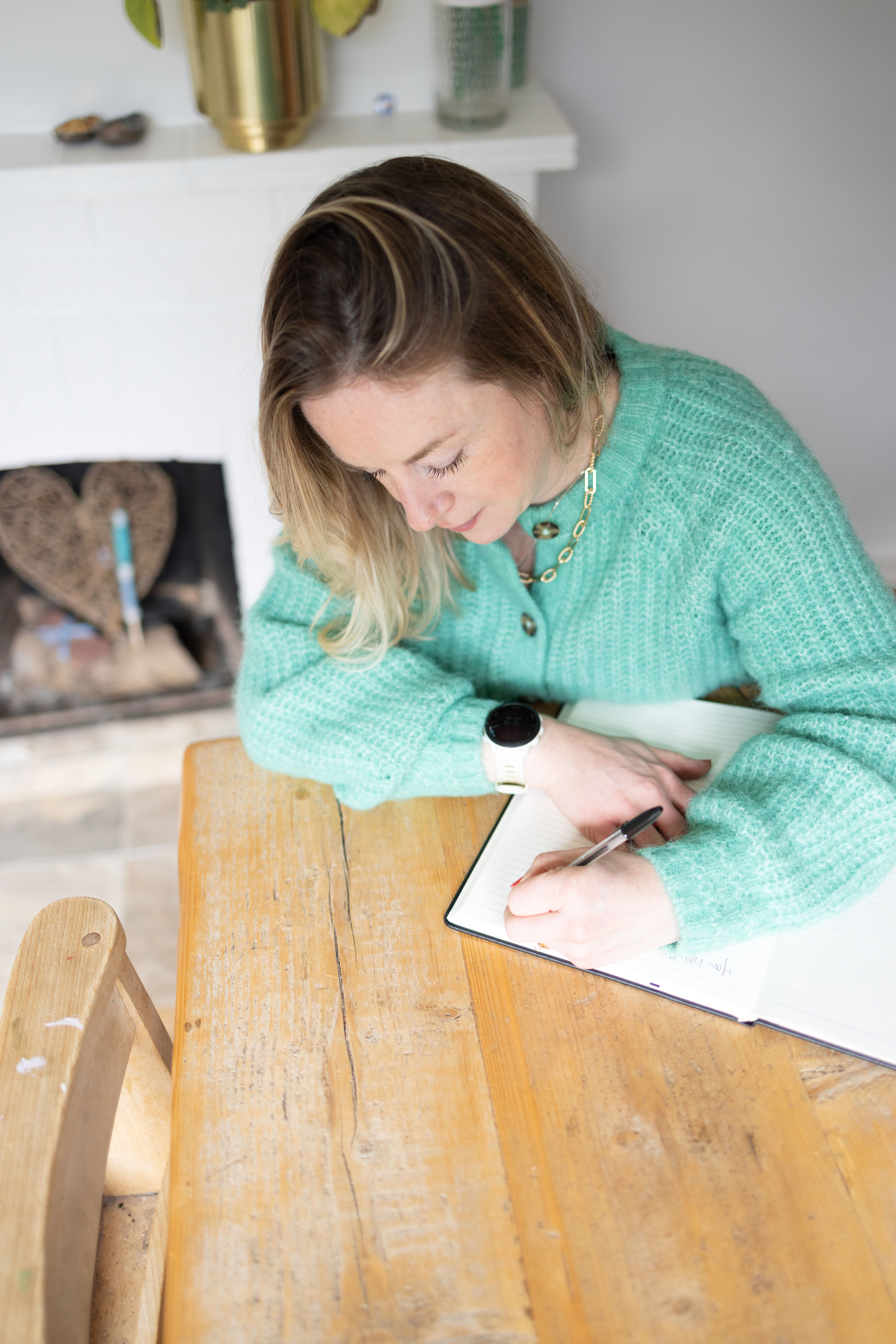 Dr Kate Ella writing notes at a wooden table
